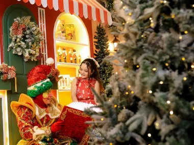 Duende Mágico e menina abrindo livro de histórias de Natal que brilha com luz dourada mágica no estúdio