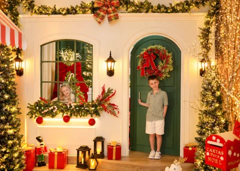 Fachada colonial autoral da Vila de Natal no Estúdio Evydência em Tijucas/SC com portal verde, janela e crianças