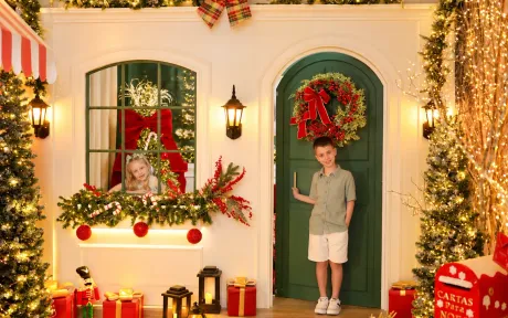 Fachada colonial autoral da Vila de Natal no Estúdio Evydência em Tijucas/SC com portal verde, janela e crianças