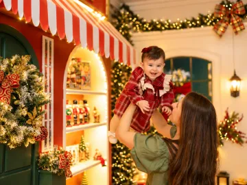 Mãe erguendo a bebê no colo com amor e cumplicidade na loja de brinquedos da Vila de Natal em Tijucas
